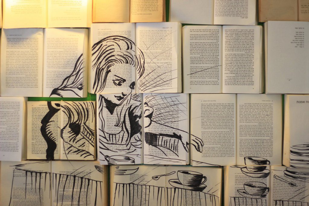 קיר מכוסה ספרים ועליהם ציור של אליס בארץ הפלאות