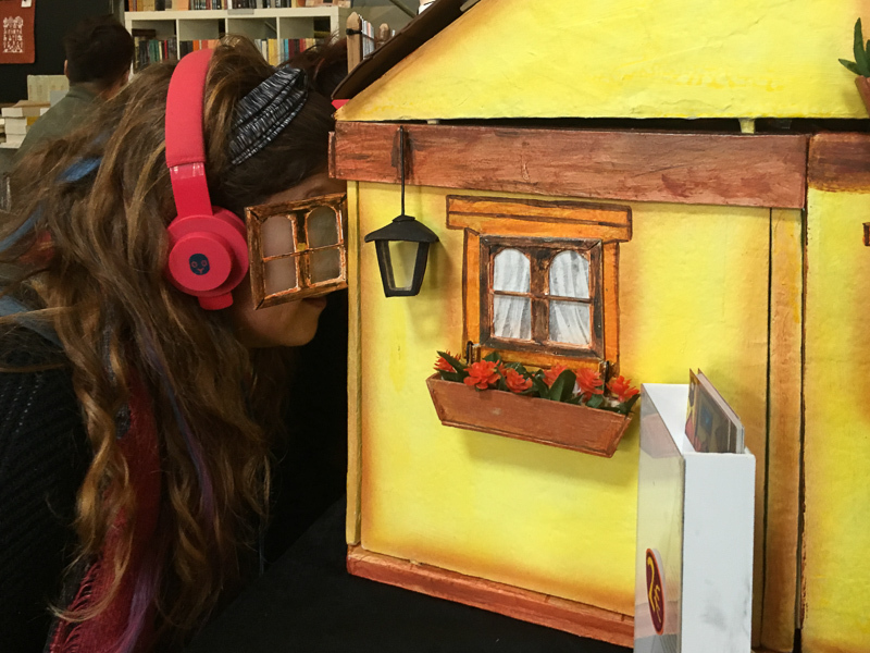 a woman watching a miniature show with headphones