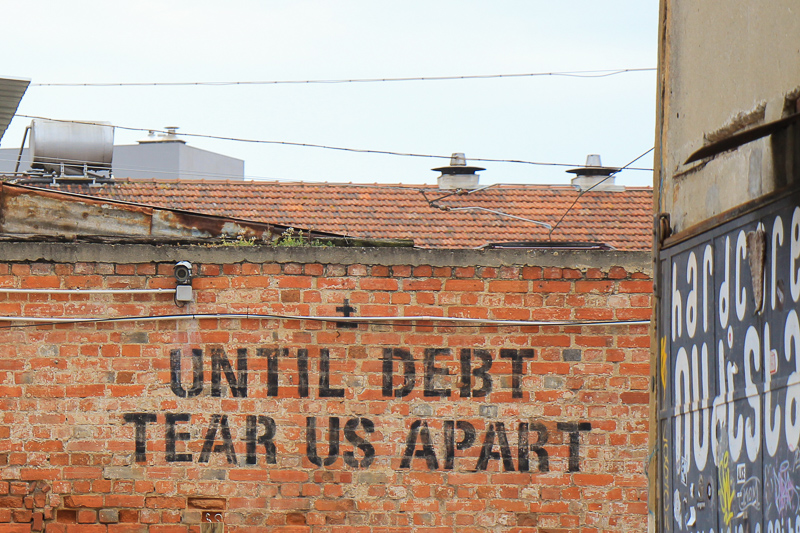 a wall with text: until debt tear us apart