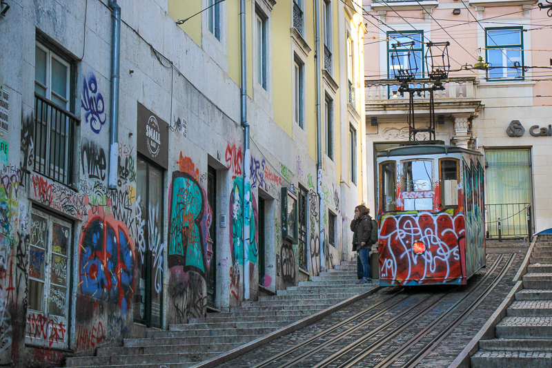 lisbon tram in a street with graphiti