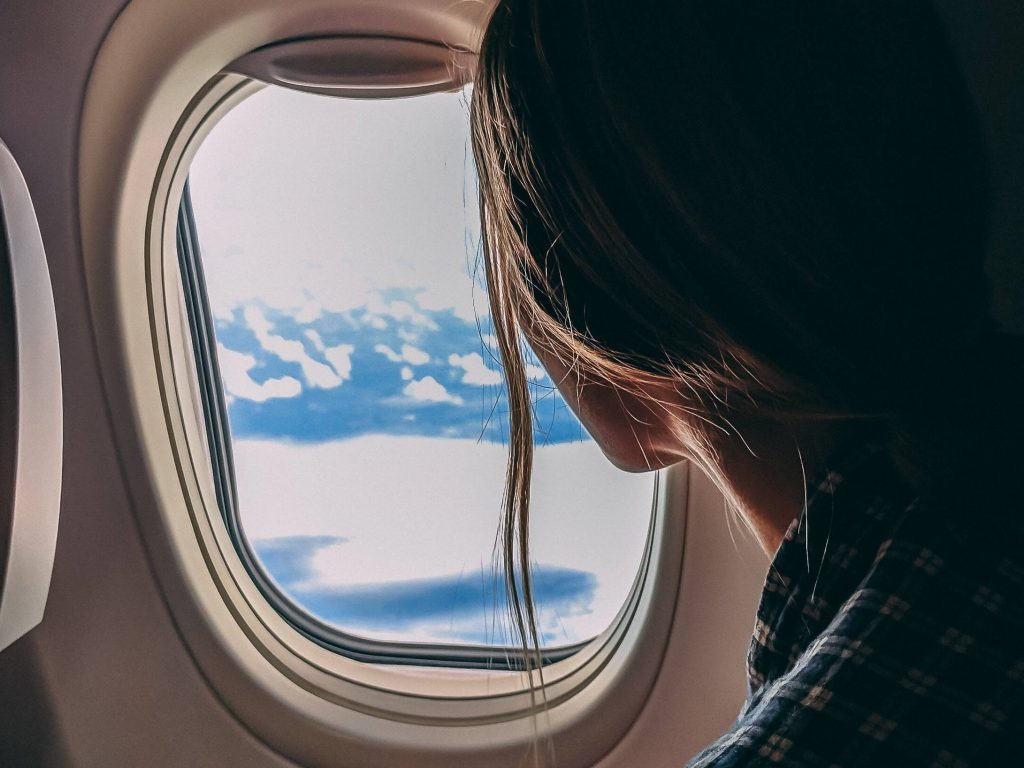 woman looking out of airplane window