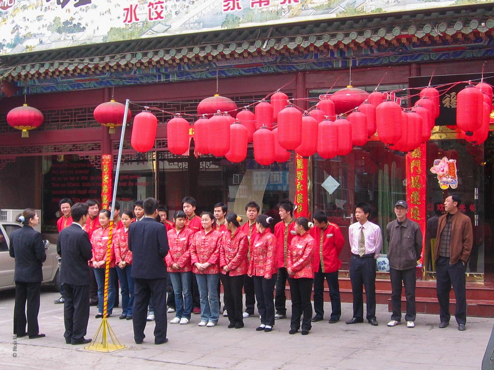קבוצת מלצרים בחולצות אדומות עומדת בפתח מסעדה