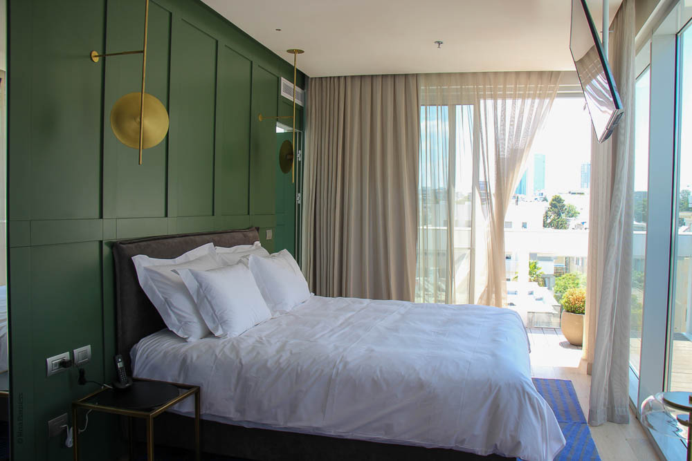 חדר המלון אינק INK. מיטה זטגית על רקע קיר ירוק
