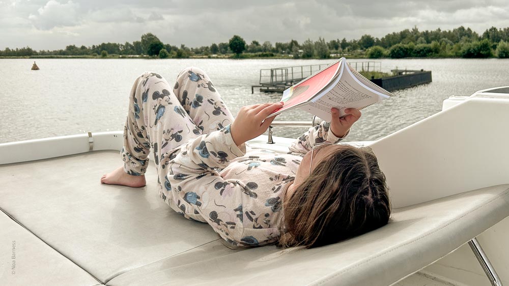 ילדה קוראת על סיפון הסירה